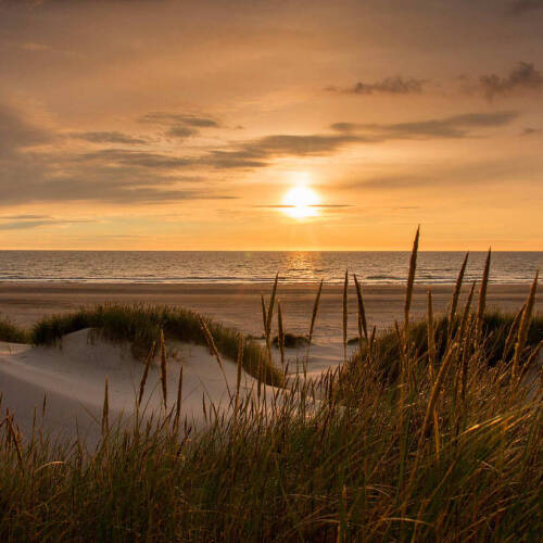 A sunset over a sand due